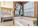 Bright bathroom features a soaking tub, stylish towel racks, and a sunlit window at 19602 E 63Rd Dr, Aurora, CO 80019