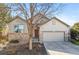 Traditional home with a two-car garage, stone accents, mature landscaping and inviting curb appeal at 19602 E 63Rd Dr, Aurora, CO 80019
