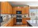 Kitchen area featuring wooden cabinetry, granite countertops, stainless steel appliances and a window for natural light at 19602 E 63Rd Dr, Aurora, CO 80019