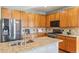 Kitchen area featuring wooden cabinetry, granite countertops, stainless steel appliances, and a center island with sink at 19602 E 63Rd Dr, Aurora, CO 80019