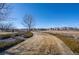 Scenic community park view showcasing lush grass, walking paths, and manicured hedges under a clear sky at 19602 E 63Rd Dr, Aurora, CO 80019