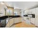 Well-lit kitchen with black countertops, white cabinets, and stainless steel appliances at 2164 S Troy Way, Aurora, CO 80014