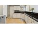 Well-lit kitchen with white cabinets, black countertop, and modern appliances at 2164 S Troy Way, Aurora, CO 80014