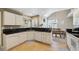 Bright, functional kitchen featuring white cabinets and black countertops, adjacent to the dining area at 2164 S Troy Way, Aurora, CO 80014