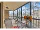 Bright sunroom with large windows showcasing neighborhood views, furnished with a table and chairs for relaxing at 13631 E Marina Dr # 105, Aurora, CO 80014