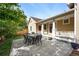 Charming backyard patio featuring a dining set and lush greenery with home exterior view at 9134 E 29Th Pl, Denver, CO 80238
