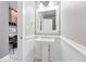 A half bathroom with a pedestal sink, wainscoting, and black and white tile floors at 9134 E 29Th Pl, Denver, CO 80238
