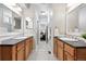 Bright bathroom with double vanity, black countertop, and black and white checkered tile floor leading to bedroom at 9134 E 29Th Pl, Denver, CO 80238