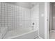 Shower and tub area with white tile walls and a bathtub, creating a clean and inviting bathing experience at 9134 E 29Th Pl, Denver, CO 80238