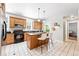 Bright kitchen with tile floors, center island with barstool seating and stainless steel appliances at 9134 E 29Th Pl, Denver, CO 80238