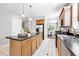Well-lit kitchen featuring an island, tile floors, and stainless steel sink overlooking the dining area at 9134 E 29Th Pl, Denver, CO 80238