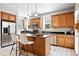 Bright kitchen with tile floors, center island with barstool seating and stainless steel appliances at 9134 E 29Th Pl, Denver, CO 80238