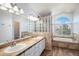 Elegant bathroom with dual sinks, stylish tile work, and a luxurious soaking tub by a large window at 510 W Prestwick Way, Castle Rock, CO 80104