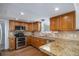 Well-equipped kitchen with stainless steel appliances, granite countertops, and wood cabinets at 510 W Prestwick Way, Castle Rock, CO 80104