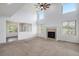 Bright living room with neutral carpet, fireplace, and tall windows showcasing the outdoor view at 510 W Prestwick Way, Castle Rock, CO 80104