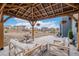 Cozy outdoor pergola featuring cushioned seating, hanging flower baskets, and neighborhood views at 510 W Prestwick Way, Castle Rock, CO 80104
