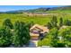 Aerial view of a two-story home surrounded by mature trees with a mountain backdrop at 12534 W Hoover Ave, Littleton, CO 80127