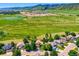Scenic aerial view of a neighborhood with lush green spaces, a pond, and mountain views at 12534 W Hoover Ave, Littleton, CO 80127