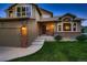 Beautiful residence showcasing a well-manicured lawn, brick accents, a two-car garage, and a cozy front entry at 12534 W Hoover Ave, Littleton, CO 80127