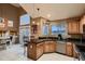 Bright kitchen featuring wooden cabinets, granite countertops, stainless steel appliances, and an eat-in breakfast bar at 12534 W Hoover Ave, Littleton, CO 80127