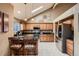 Spacious kitchen boasting wooden cabinets, granite countertops, stainless steel appliances, and a cozy breakfast bar at 12534 W Hoover Ave, Littleton, CO 80127