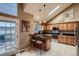 Updated kitchen featuring stainless steel appliances, granite countertops, an island with seating, and custom cabinets at 12534 W Hoover Ave, Littleton, CO 80127