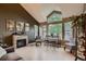 Bright living room with a stone fireplace, high ceilings, large windows, and stylish furnishings at 12534 W Hoover Ave, Littleton, CO 80127