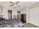 Bedroom with a ceiling fan, and a view of the bathroom and walk-in closet at 202 Ash St, Bennett, CO 80102