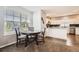 Dining area with wood table and chairs that flows into an updated kitchen with granite countertops at 202 Ash St, Bennett, CO 80102