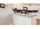Modern kitchen with white cabinets, stainless steel appliances, and granite countertops at 202 Ash St, Bennett, CO 80102