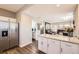 Kitchen with stainless steel refrigerator that flows into living area and half bathroom at 202 Ash St, Bennett, CO 80102