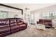 Open-concept living room featuring plush carpet, comfortable seating and plenty of natural light at 202 Ash St, Bennett, CO 80102