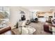 Bright open-concept living room featuring plush carpet, a comfortable seating area, and plenty of natural light at 202 Ash St, Bennett, CO 80102