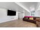 Wide shot of a basement with a plush brown couch and an adjacent TV on the wall at 34771 E 153Rd Ct, Hudson, CO 80642