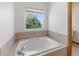 Large soaking tub framed by decorative tile and a window with natural light at 34771 E 153Rd Ct, Hudson, CO 80642