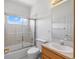 Bright bathroom with shower over tub combo, toilet and wooden vanity at 34771 E 153Rd Ct, Hudson, CO 80642