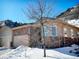 Two-story home with stone accents, a snowy yard, and a large tree in front at 6945 Fargo Trl, Littleton, CO 80125