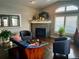 Living room with a corner fireplace, hardwood floors, and large windows with plantation shutters at 6945 Fargo Trl, Littleton, CO 80125