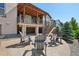 Backyard patio with chairs around firepit, stairs to upper deck, and fenced yard at 18984 W 85Th Blf, Arvada, CO 80007