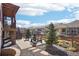 Relaxing backyard patio with stone fire pit, mature trees, and view of neighboring houses at 18984 W 85Th Blf, Arvada, CO 80007