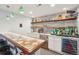 Custom bar area featuring decorative backsplash, wooden shelving, ample storage, and modern beverage cooler at 18984 W 85Th Blf, Arvada, CO 80007