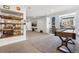 Open basement area featuring a shuffleboard table, shelving and built-in seating next to a large window at 18984 W 85Th Blf, Arvada, CO 80007