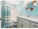 Inviting bathroom with modern fixtures, a round decorative mirror, and a stylish striped shower curtain at 18984 W 85Th Blf, Arvada, CO 80007