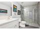Modern bathroom featuring tiled walls, frameless shower, and marble vanity at 18984 W 85Th Blf, Arvada, CO 80007