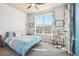 Cozy bedroom with a comfortable bed, rocking chair, and large window showcasing neighborhood views at 18984 W 85Th Blf, Arvada, CO 80007