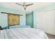 Bedroom featuring a ceiling fan, striped bedspread, and a spacious closet with white doors at 18984 W 85Th Blf, Arvada, CO 80007