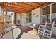 Covered outdoor deck with rocking chairs and colorful decor at 18984 W 85Th Blf, Arvada, CO 80007