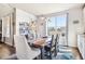 Bright dining room featuring a hardwood table, stylish seating, and large windows offering ample natural light at 18984 W 85Th Blf, Arvada, CO 80007
