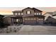 Inviting two-story home showcasing a three-car garage, covered porch, and warm exterior lighting at 18984 W 85Th Blf, Arvada, CO 80007