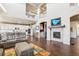 Open-concept living room with fireplace, tall ceilings, and a view of the kitchen at 18984 W 85Th Blf, Arvada, CO 80007